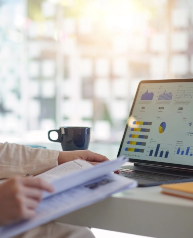 White label content built for growth and performance — reviewing notes with laptop displaying analytics graph and performance insights