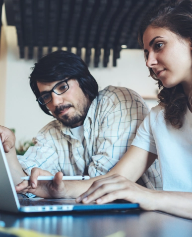 White label full-service content writing expertise — two professionals collaborating on laptop with notes and planning