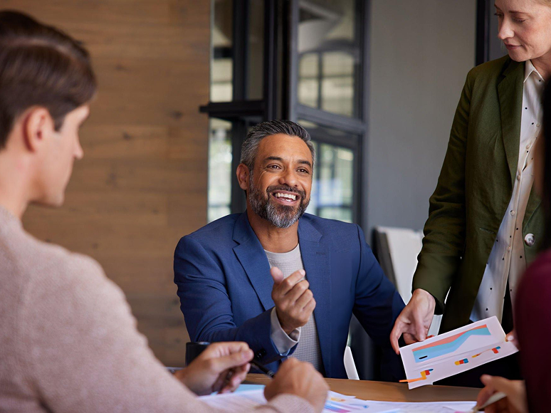 Smiling partner manager discussing revenue forecasting and business strategy with team members